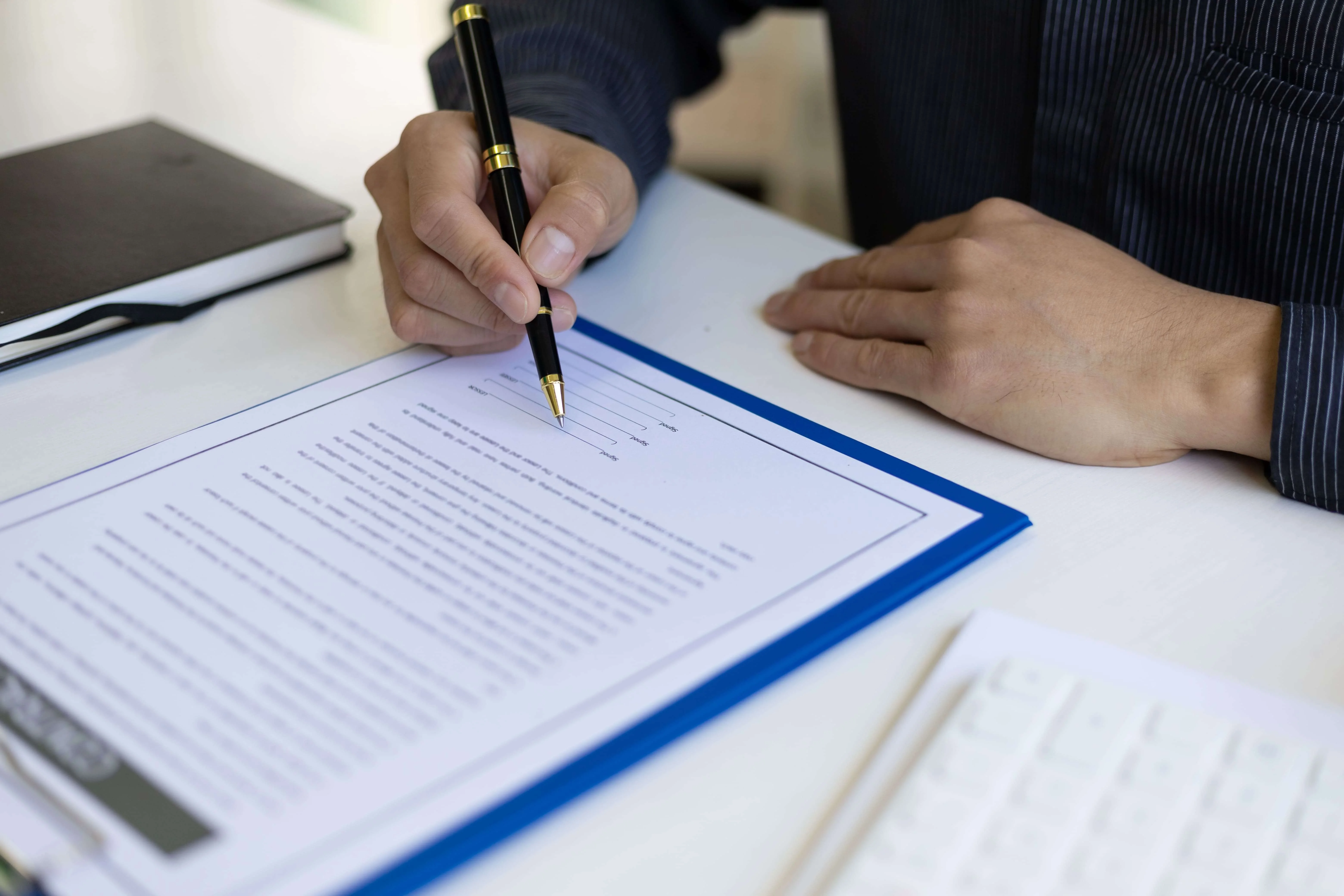 A contract document on a desk, symbolizing Purchase and Sale Contracts in real estate transactions. This complements the description of Defiant Law Group's Contract Mastery. It represents their expertise in preparing, negotiating, and reviewing purchase and sale contracts, ensuring a secure and successful real estate deal.